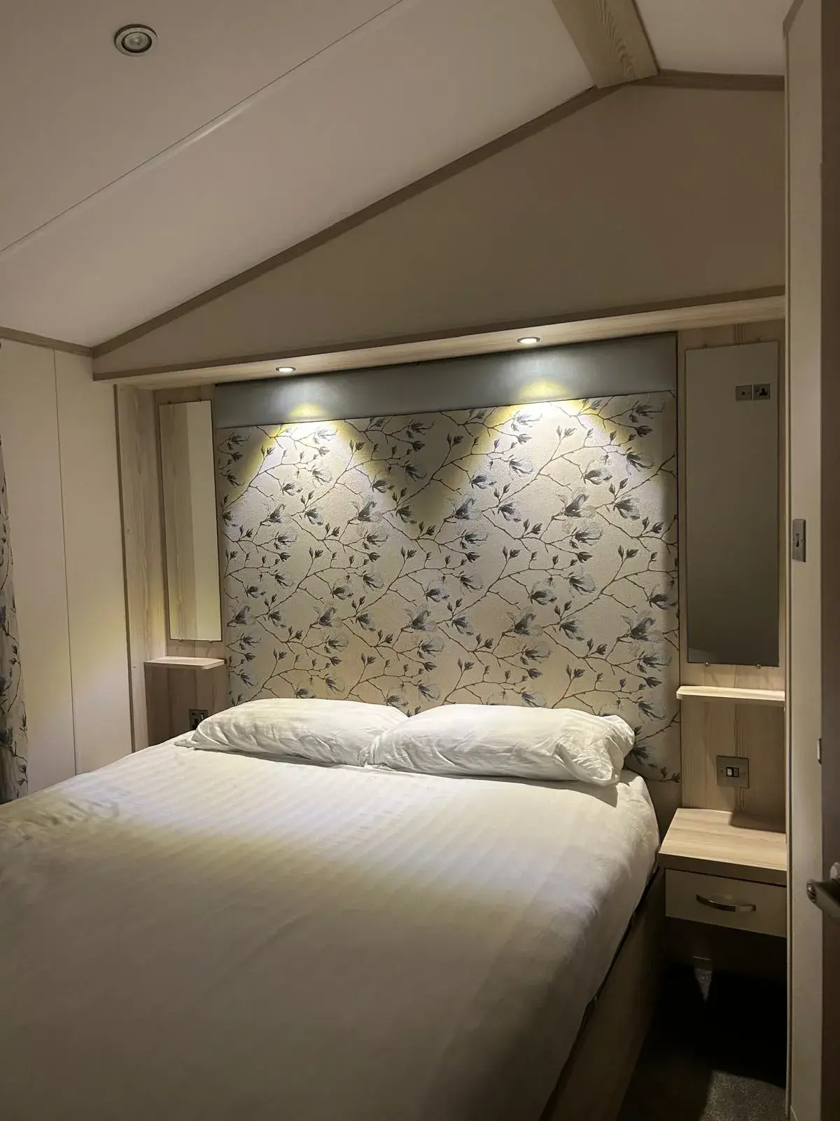 Master double bedroom with feature wall and wall lights, Cornwall Lodge