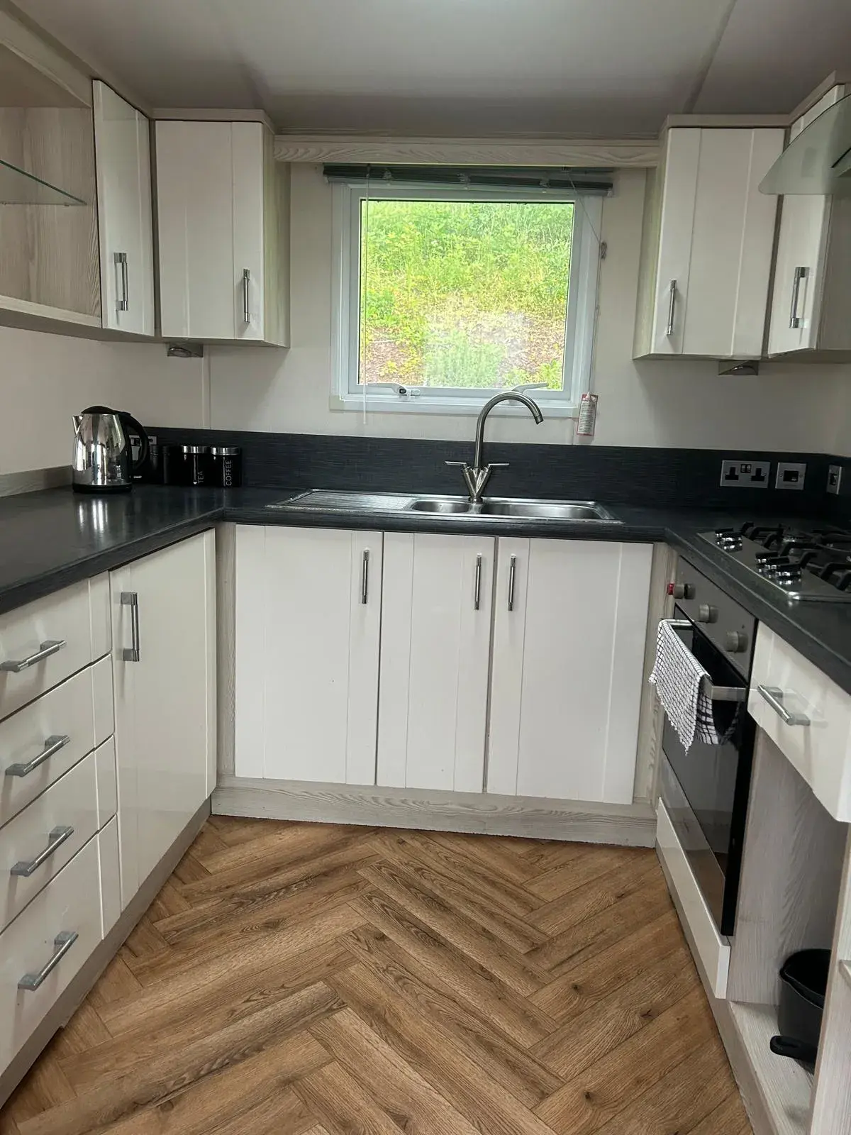 Fully-fitted kitchen with gas hob, oven and herringbone flooring, Cornwall Lodge