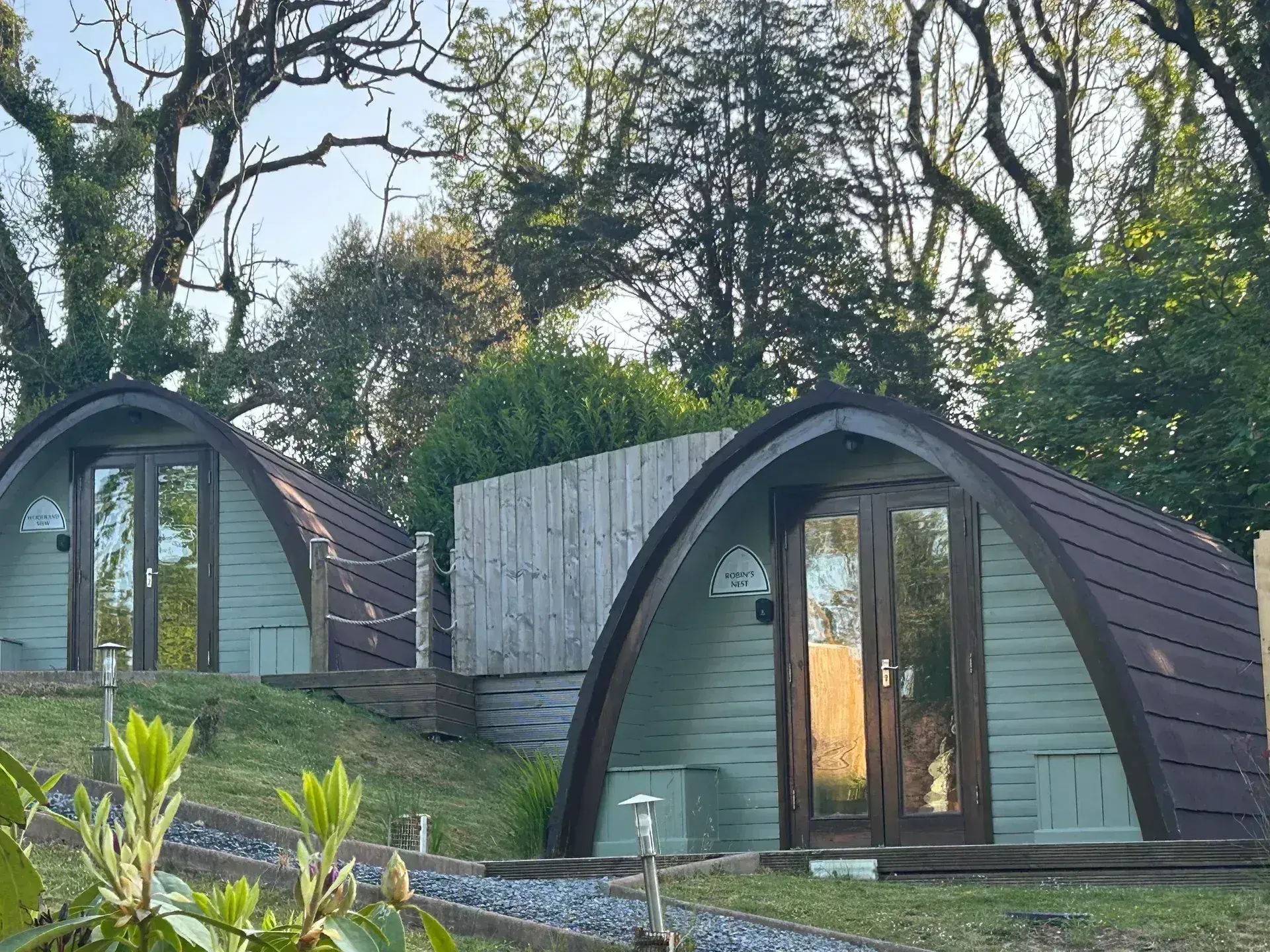 Two luxury glamping pods at Broadway in golden evening light