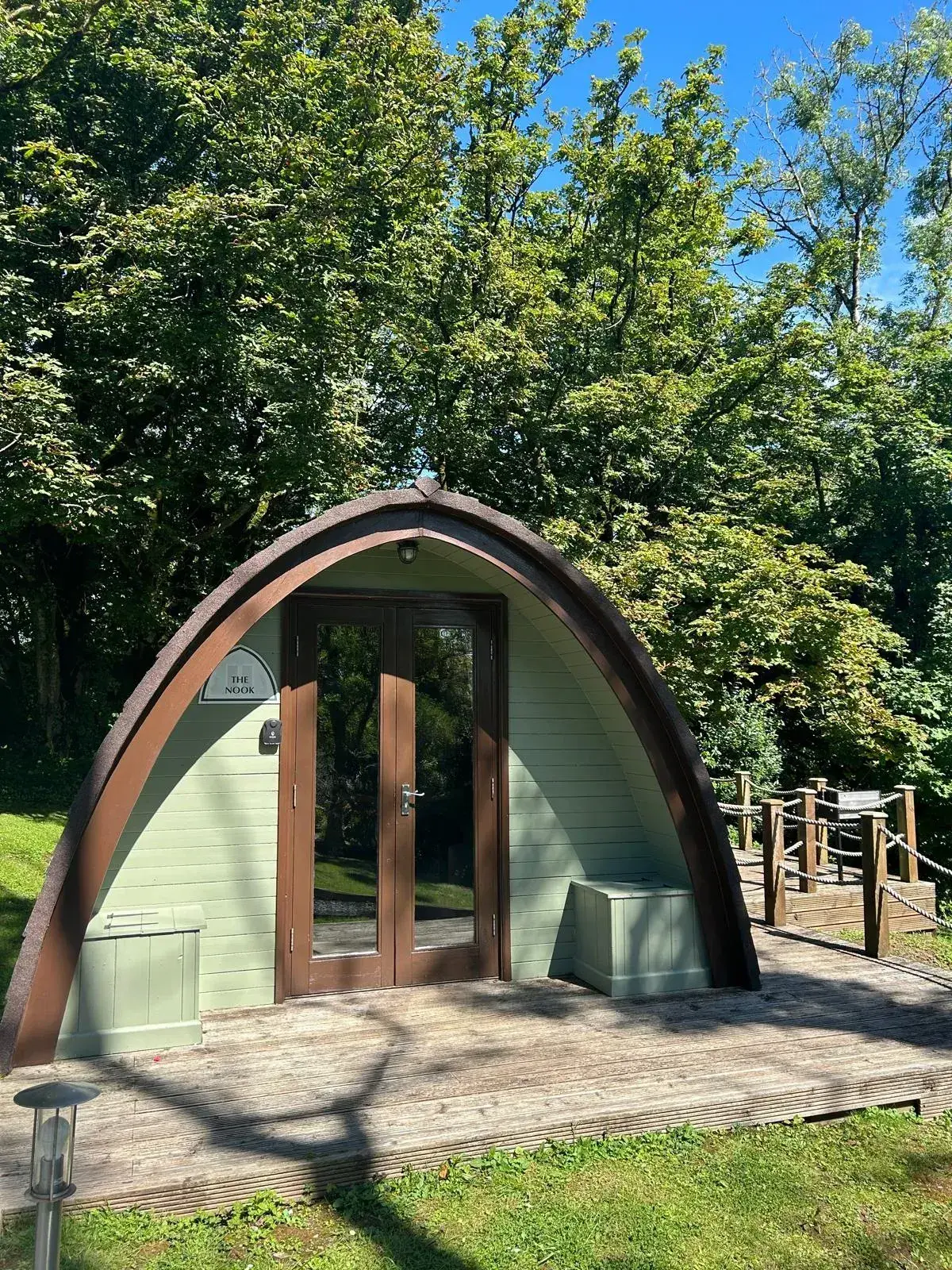 Standard Pod exterior in autumn, with private decking and a picnic table amongst the trees