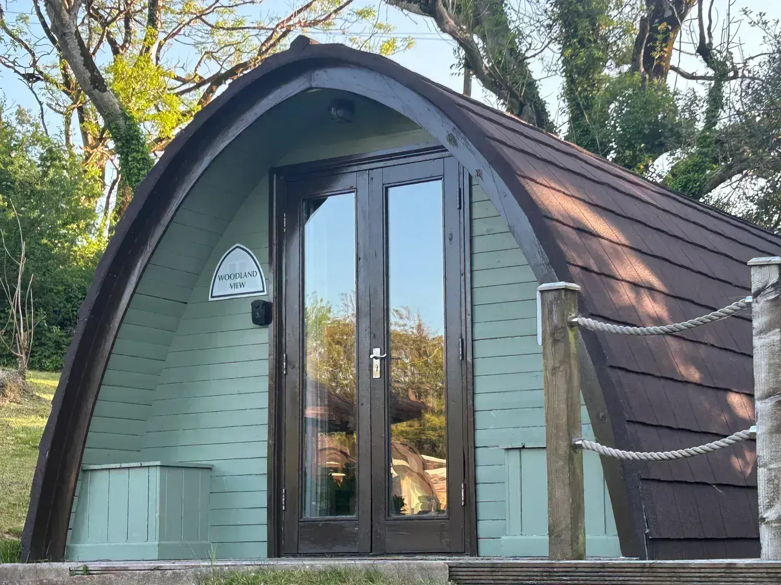 Hot tub glamping pod — arched entrance with decking and rope railing