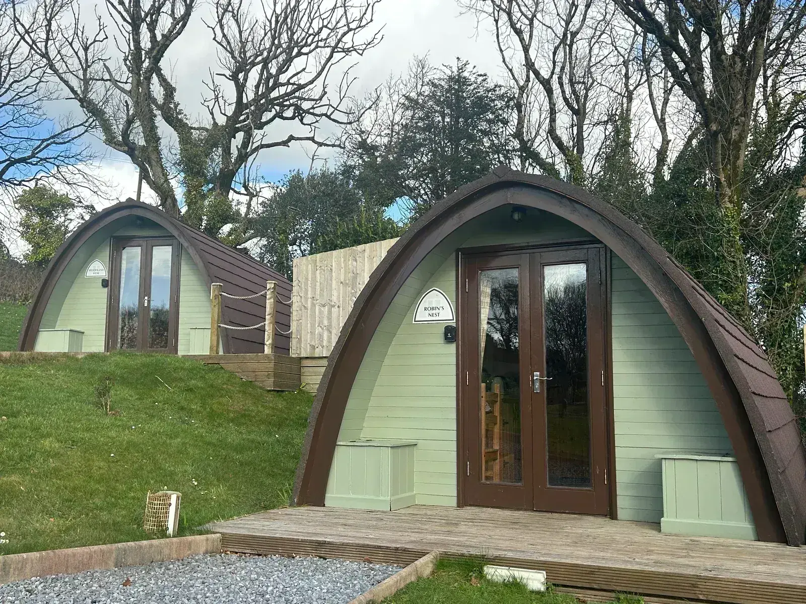 Two glamping pods with private decking, rope railings and picnic seating